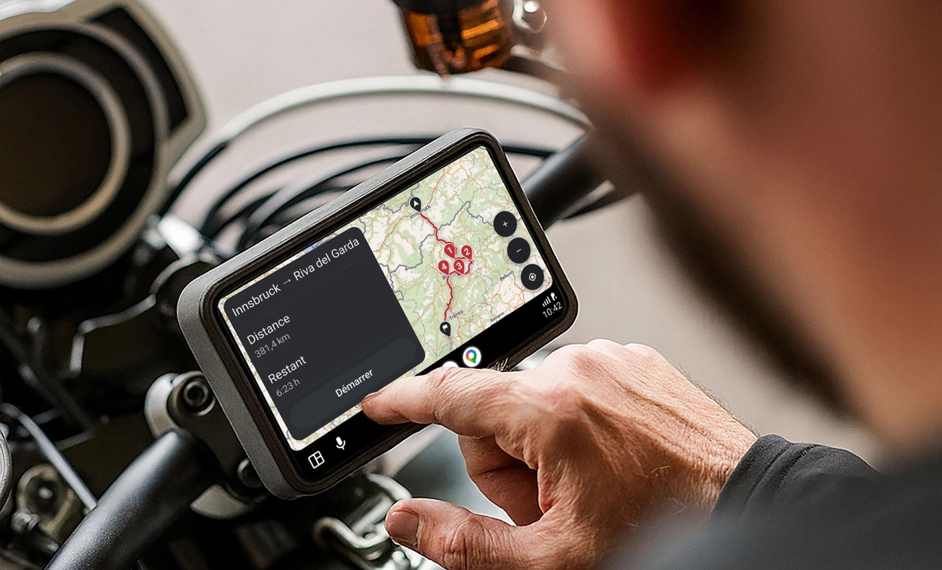 Route de montagne sinueuse dans un paysage verdoyant avec interface de l'appli affichée pour planifier un circuit.