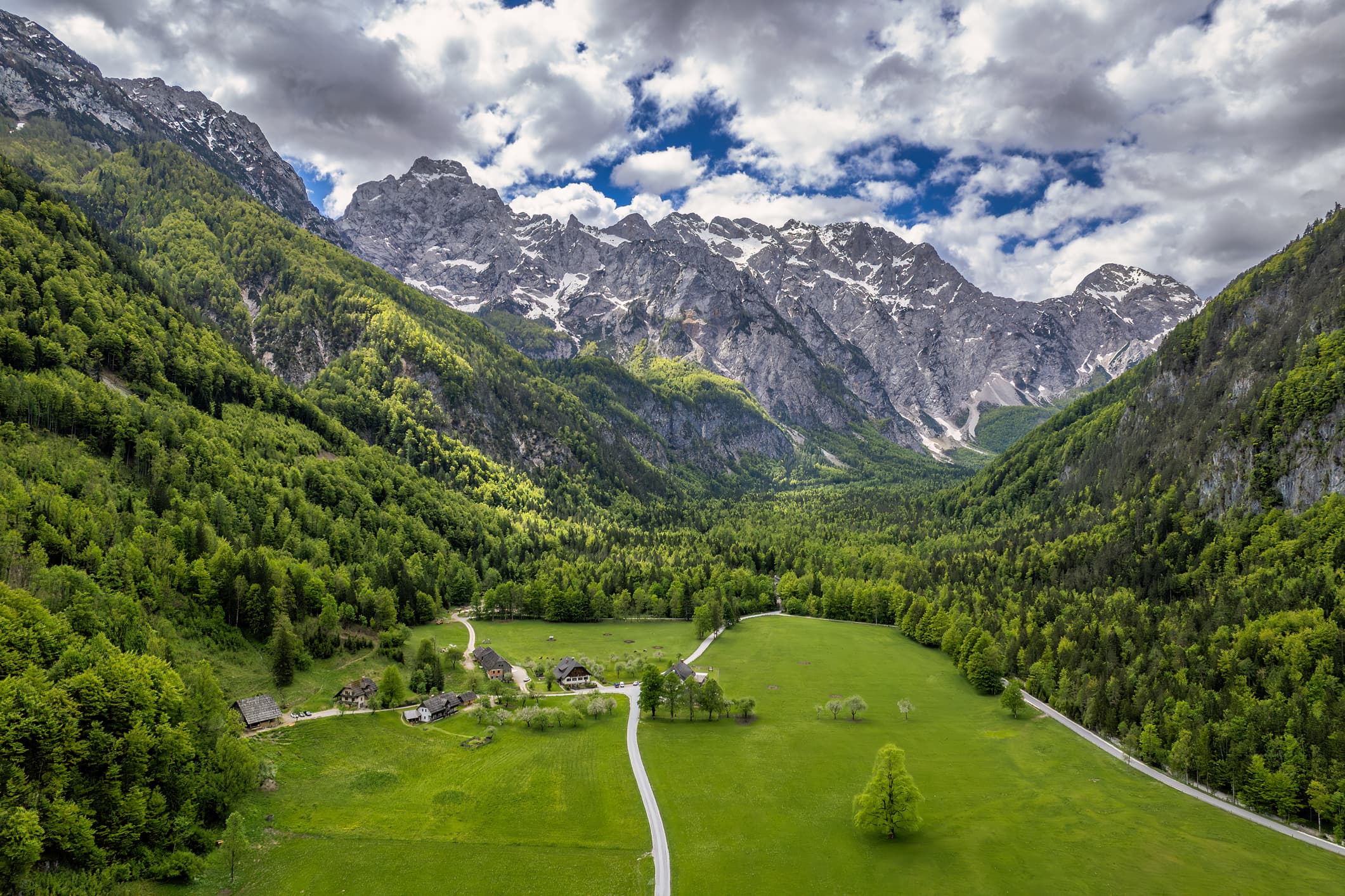 Green meadows and valleys with snow-covered mountains in the background in the Logar Valley